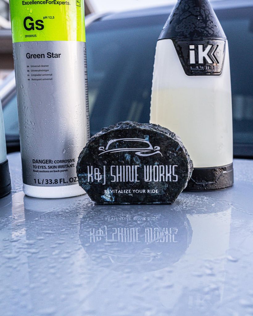 Koch Chemie Green Star cleaner and an iK sprayer beside a K&J Shine Works branded puck on a freshly detailed hood