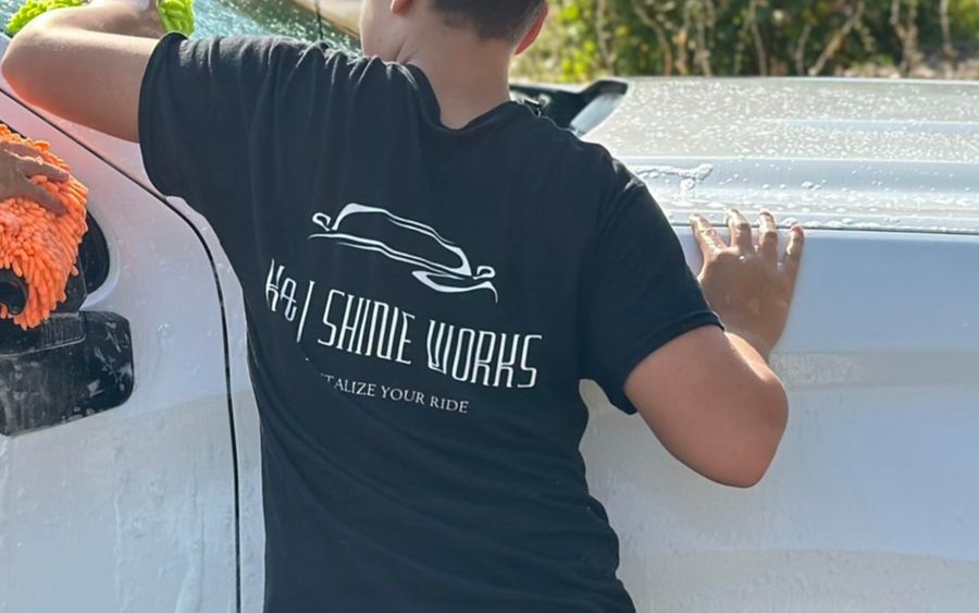 K&J Shine Works detailer hand-washing a white truck with a wash mitt
